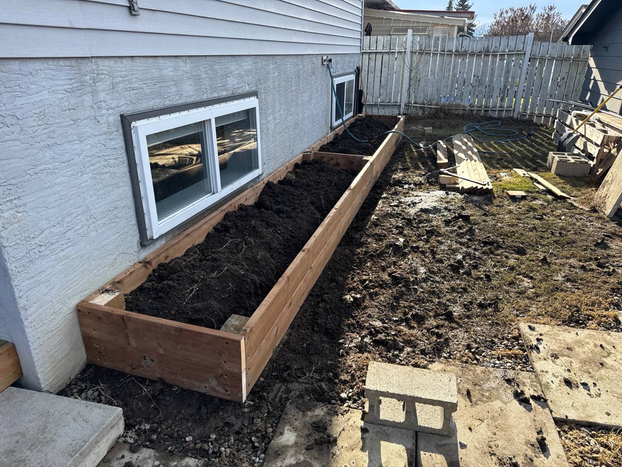 Raised cedar planter bed along house foundation