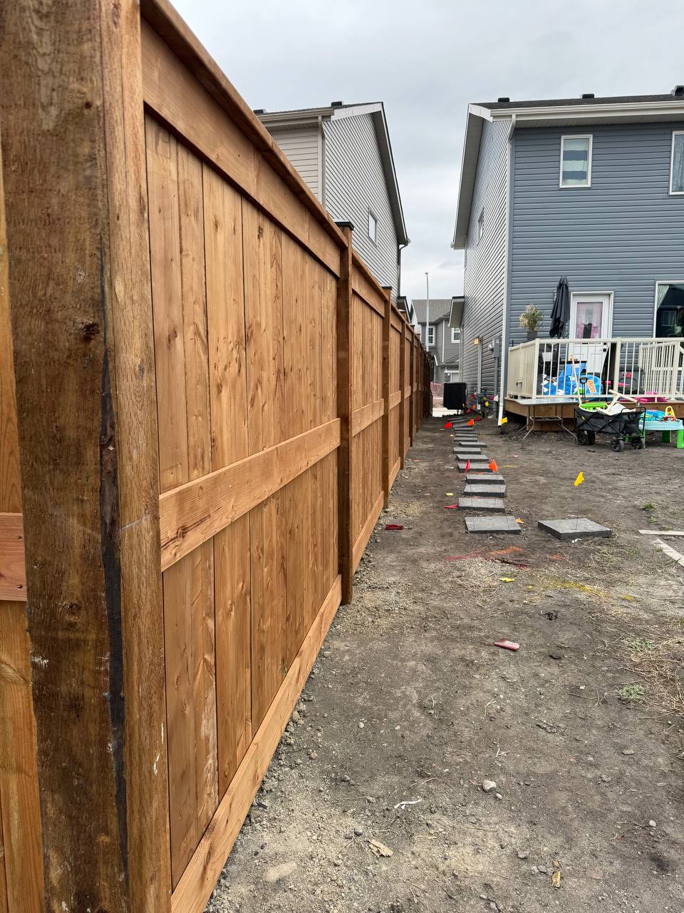 Installation of concrete stepping stones in residential backyard with construction in progress