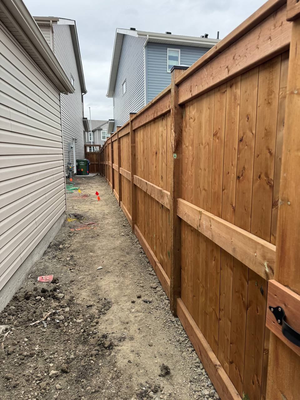 Newly installed wooden privacy fence with horizontal cedar accents along residential side yard