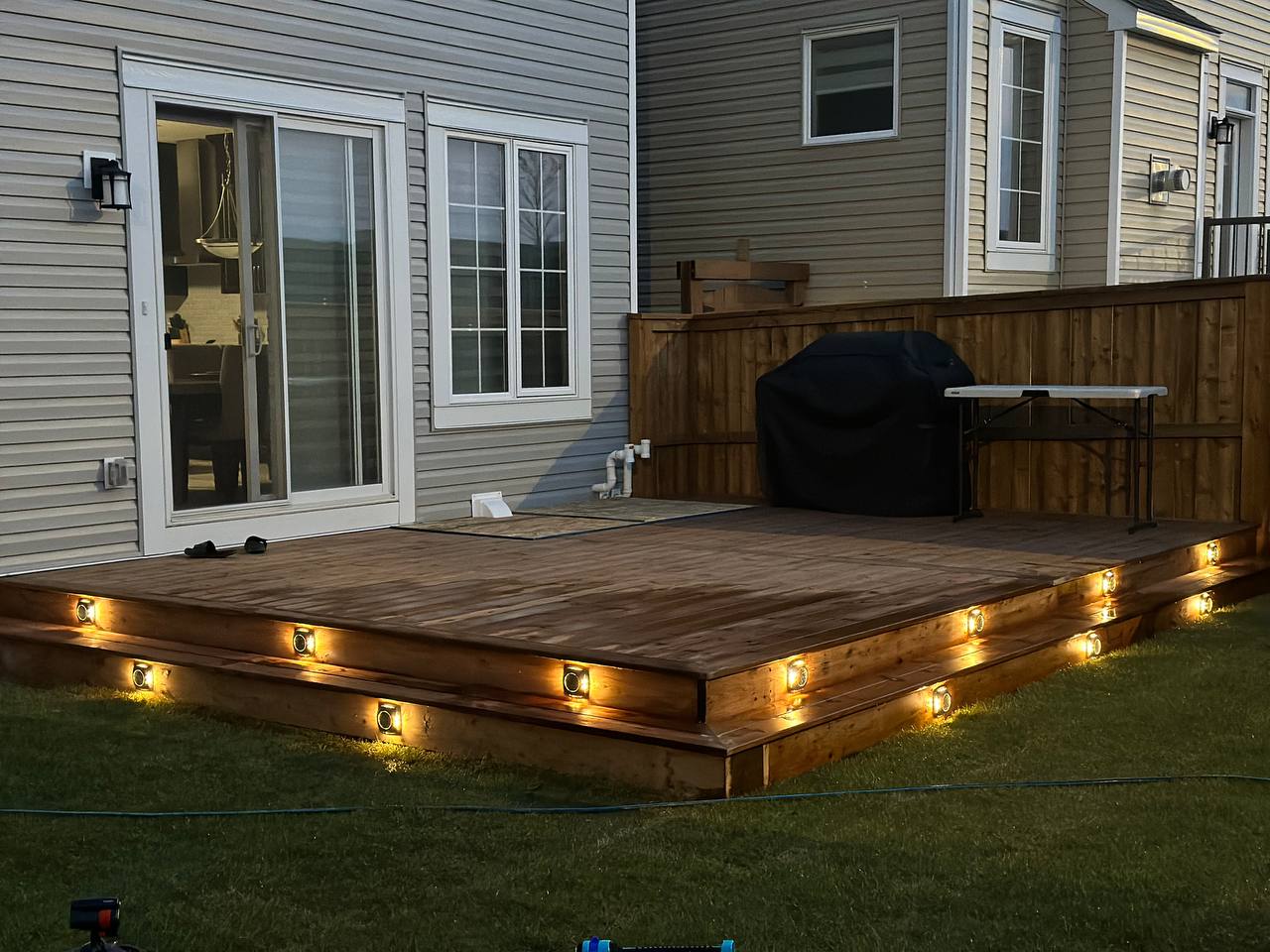 Completed composite deck with integrated LED lighting and wooden privacy fence