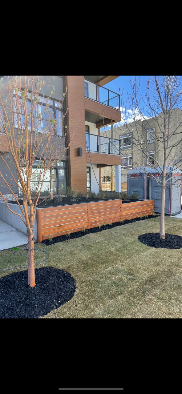 Modern horizontal wood fence with integrated planter boxes and fresh landscape installation